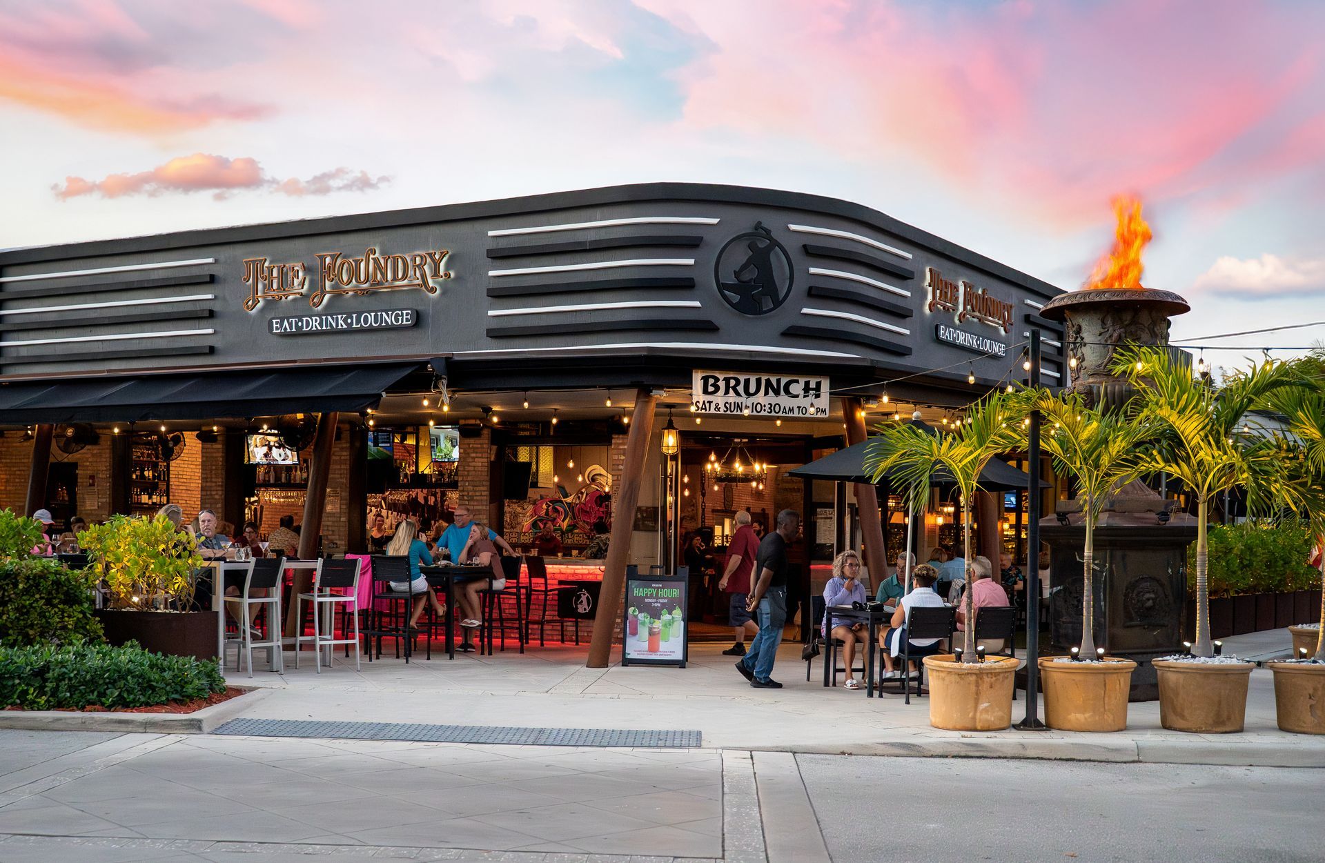 A group of people are sitting outside of a restaurant.