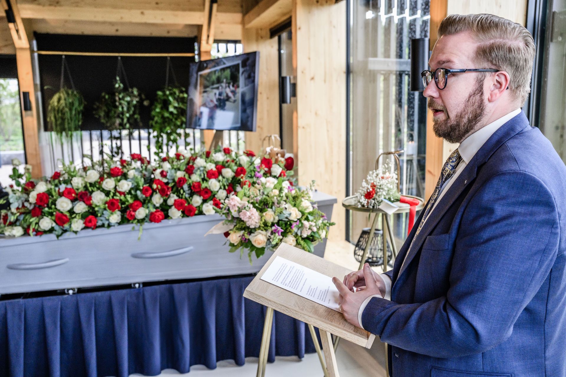 Freddy Onderstal tijdens een afscheidsdienst met bloemen bij de kist