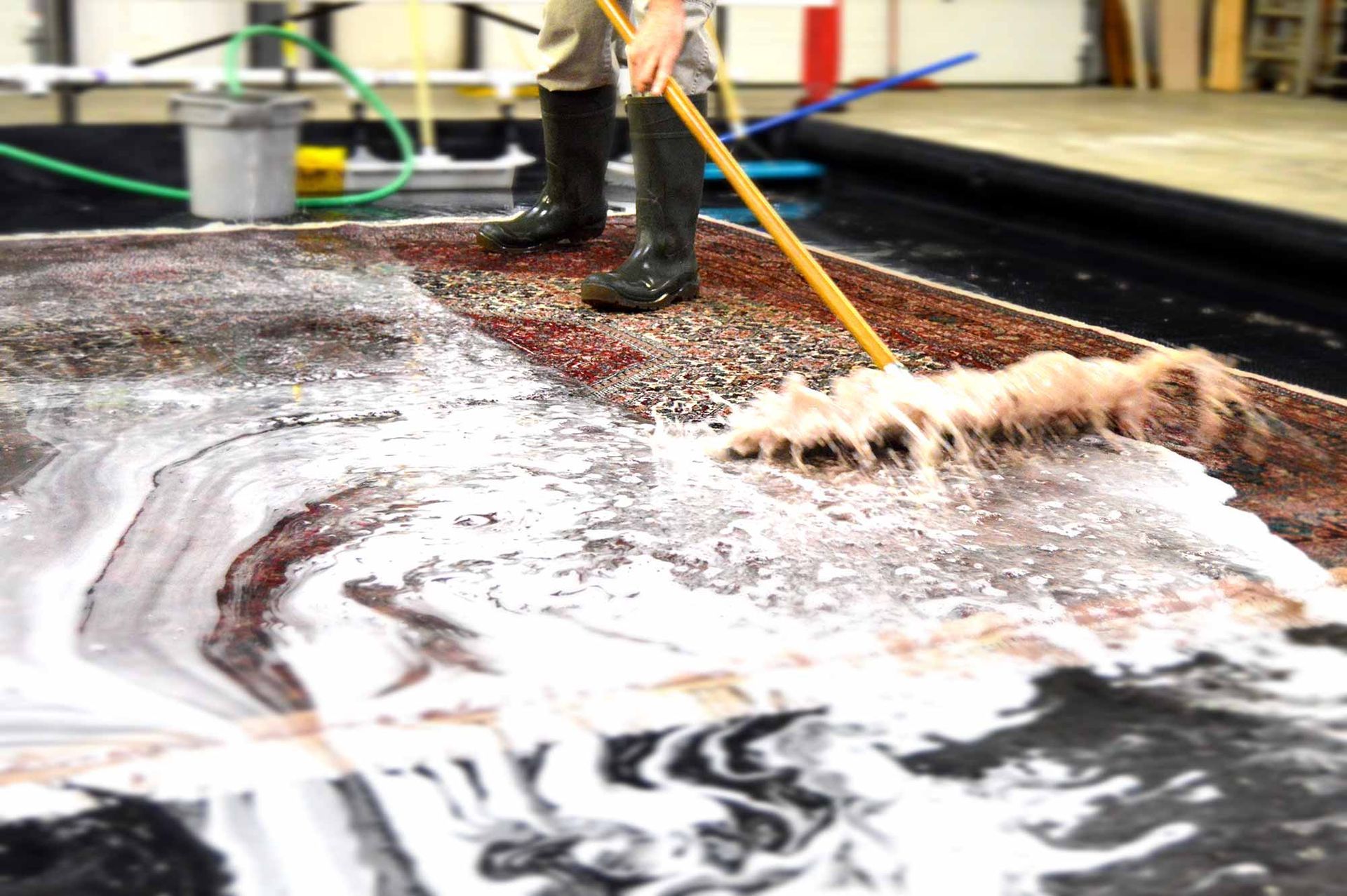 A person is cleaning a carpet with a mop