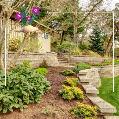 a lush green garden with a stone wall and stairs leading up to a house .