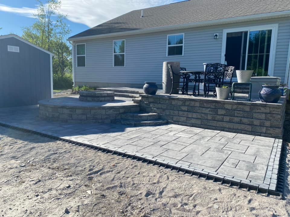 there is a patio with a table and chairs on it in front of a house .