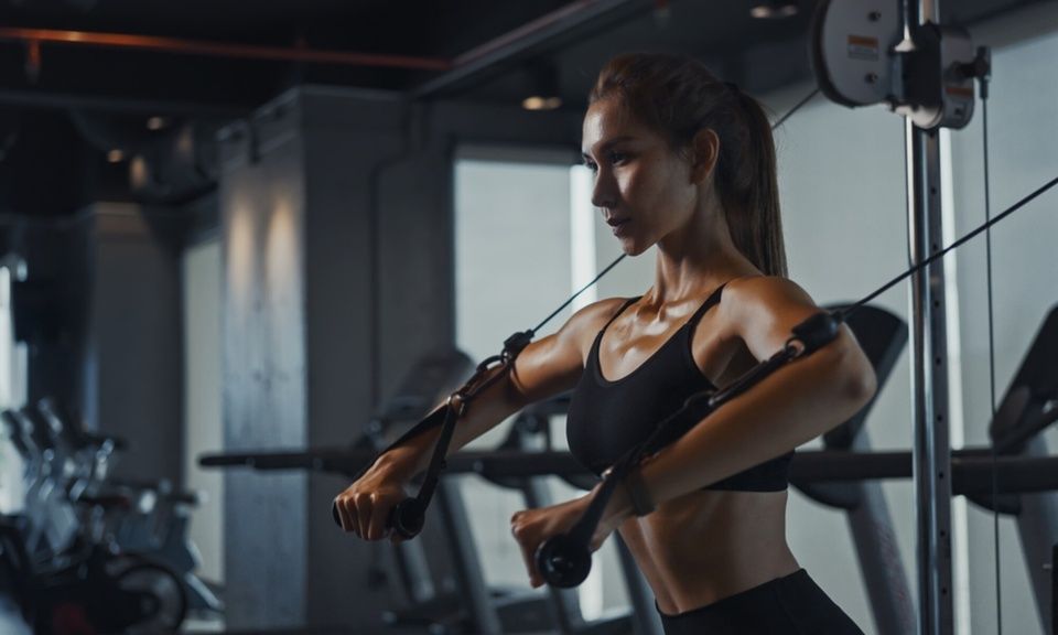 A woman is doing exercises on a machine in a gym.