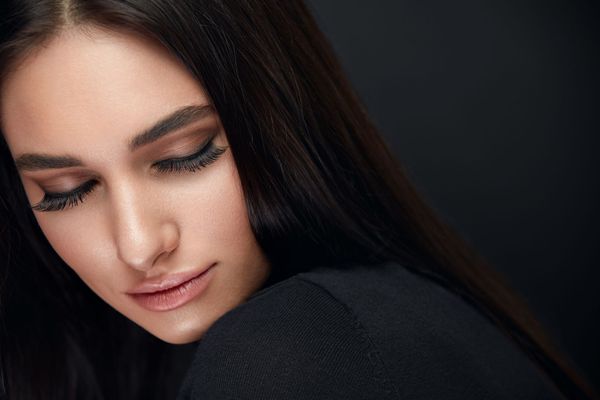 A close up of a woman 's face with her eyes closed.