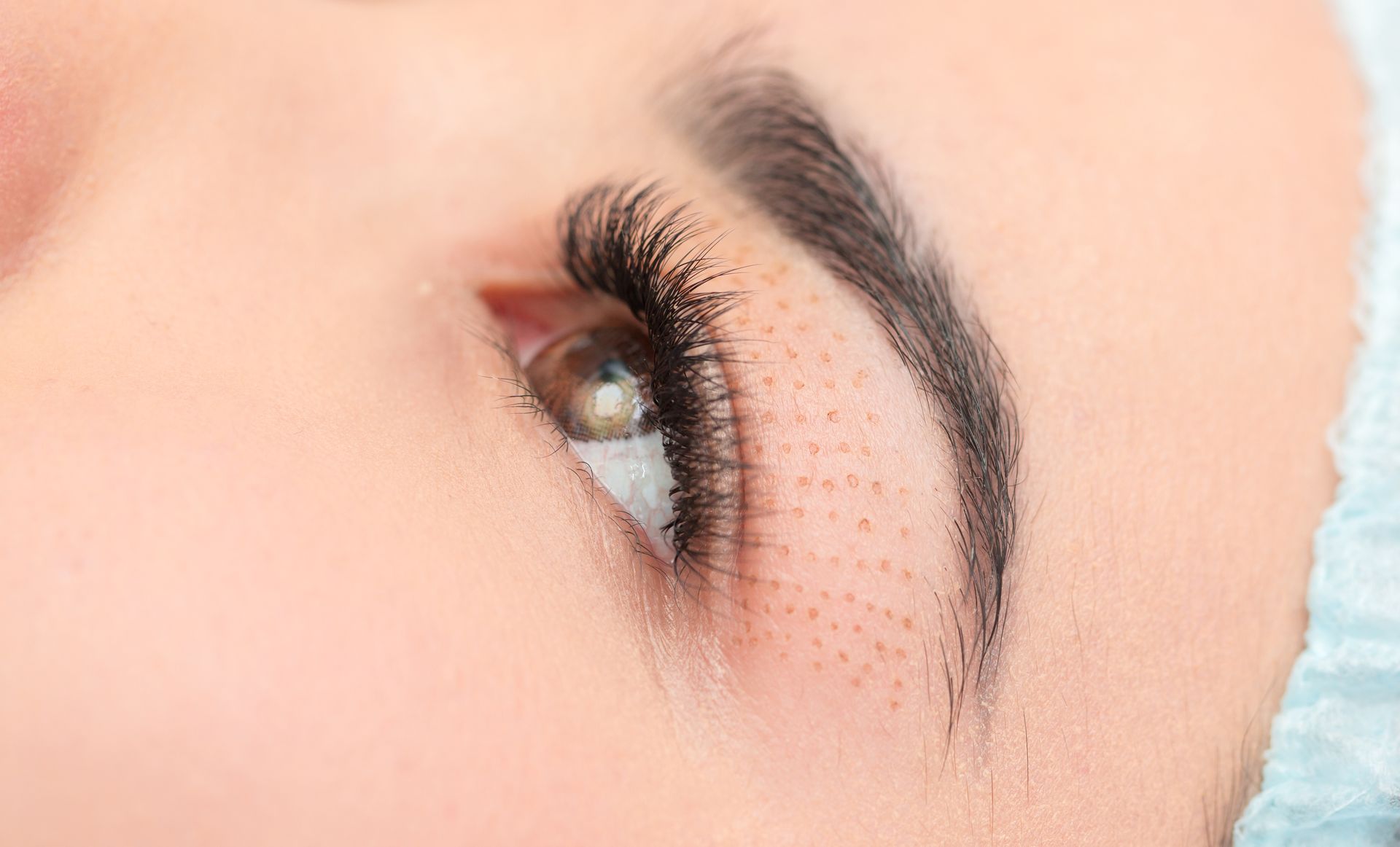 A woman is getting her eyebrows waxed in a beauty salon.