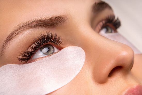 A close up of a woman 's eye with eye patches on it.