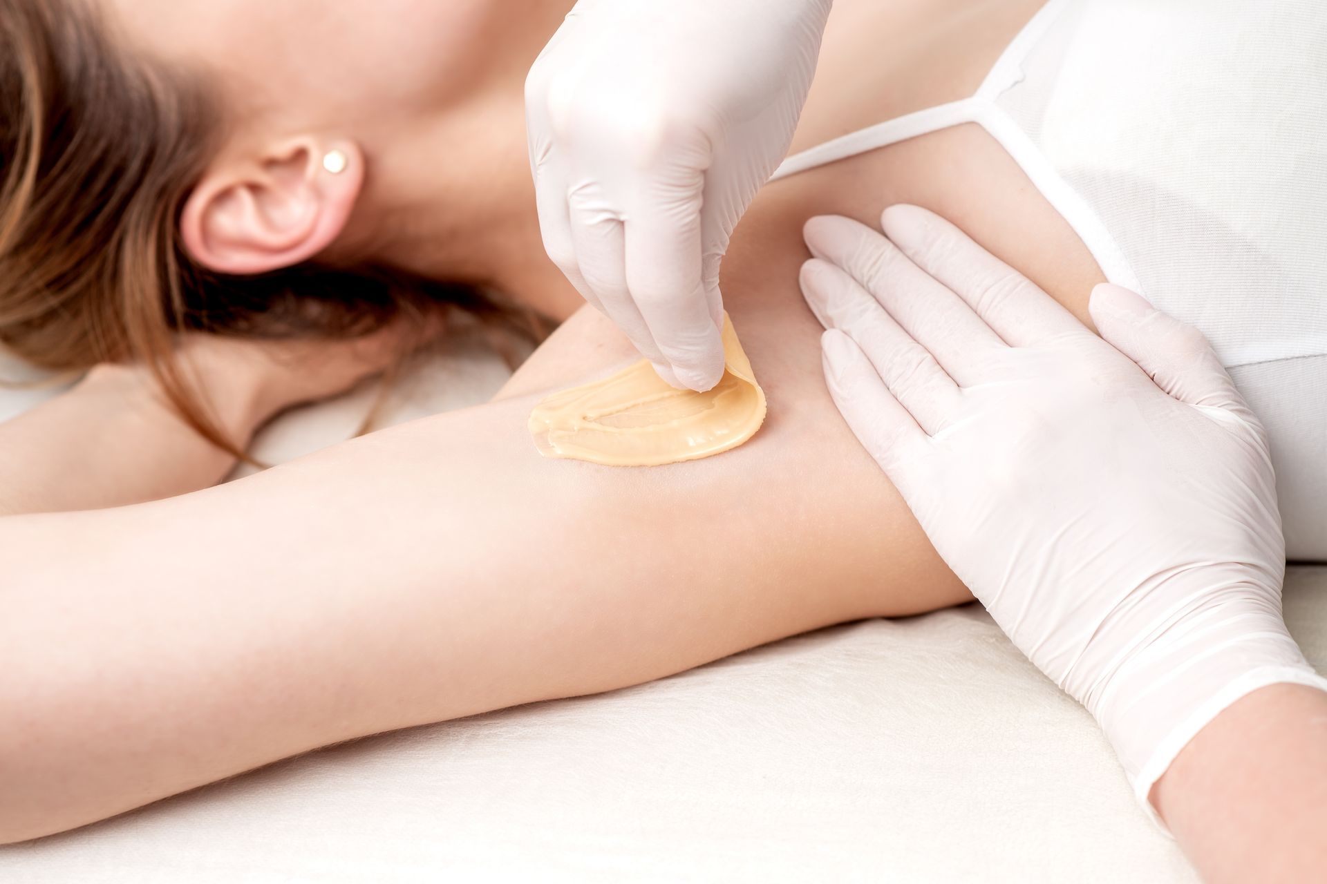 A woman is getting her armpit waxed in a beauty salon in Brantford