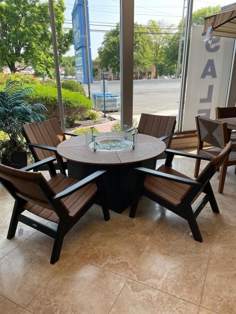 A table and chairs are sitting in front of a window.