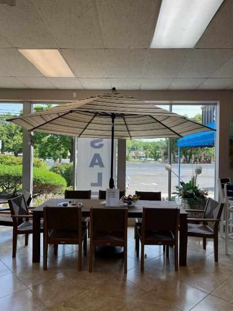 A large umbrella is in a room with a table and chairs