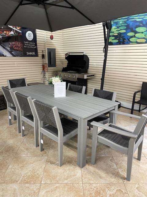 A table and chairs are sitting under an umbrella in a room.