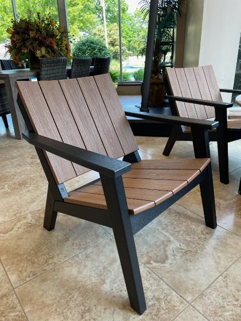 A wooden chair is sitting on a tiled floor in front of a window