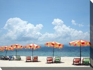 There are many umbrellas and chairs on the beach.