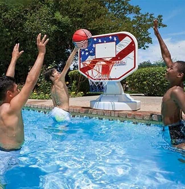 Three men are playing basketball in a swimming pool