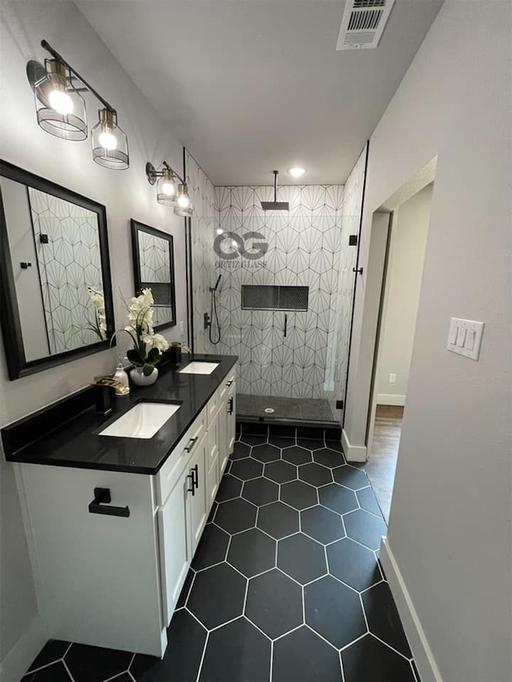 A bathroom with two sinks and a walk in shower.
