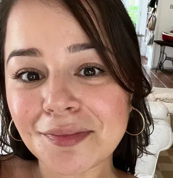 A woman wearing hoop earrings is smiling for the camera.