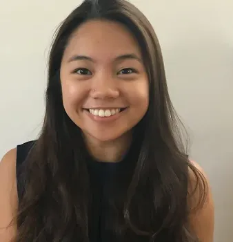 A woman with long brown hair is smiling for the camera.