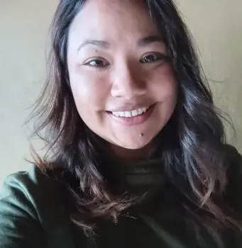 A close up of a woman taking a selfie and smiling.