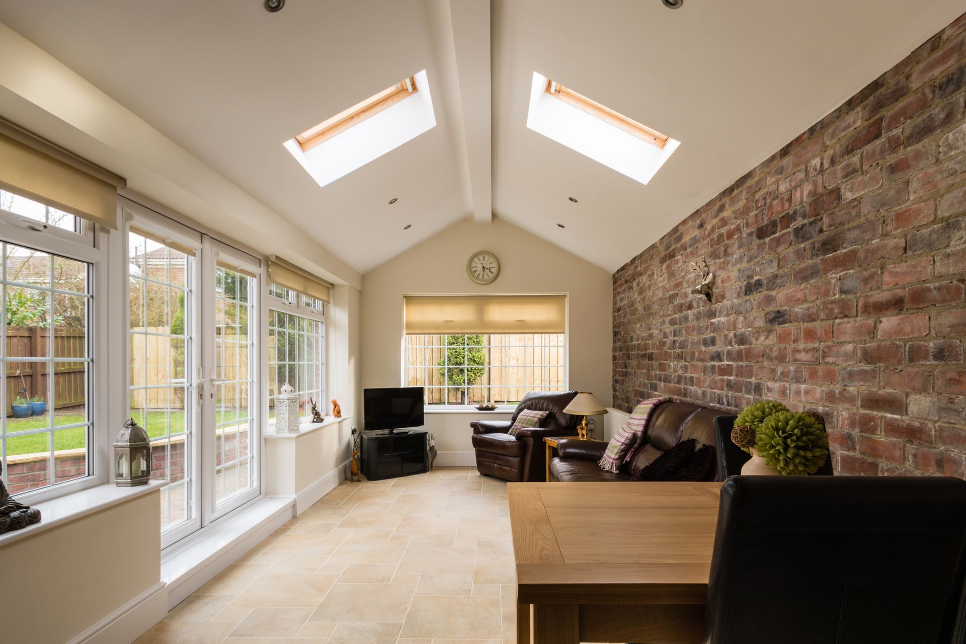 A living room with a brick wall and skylights