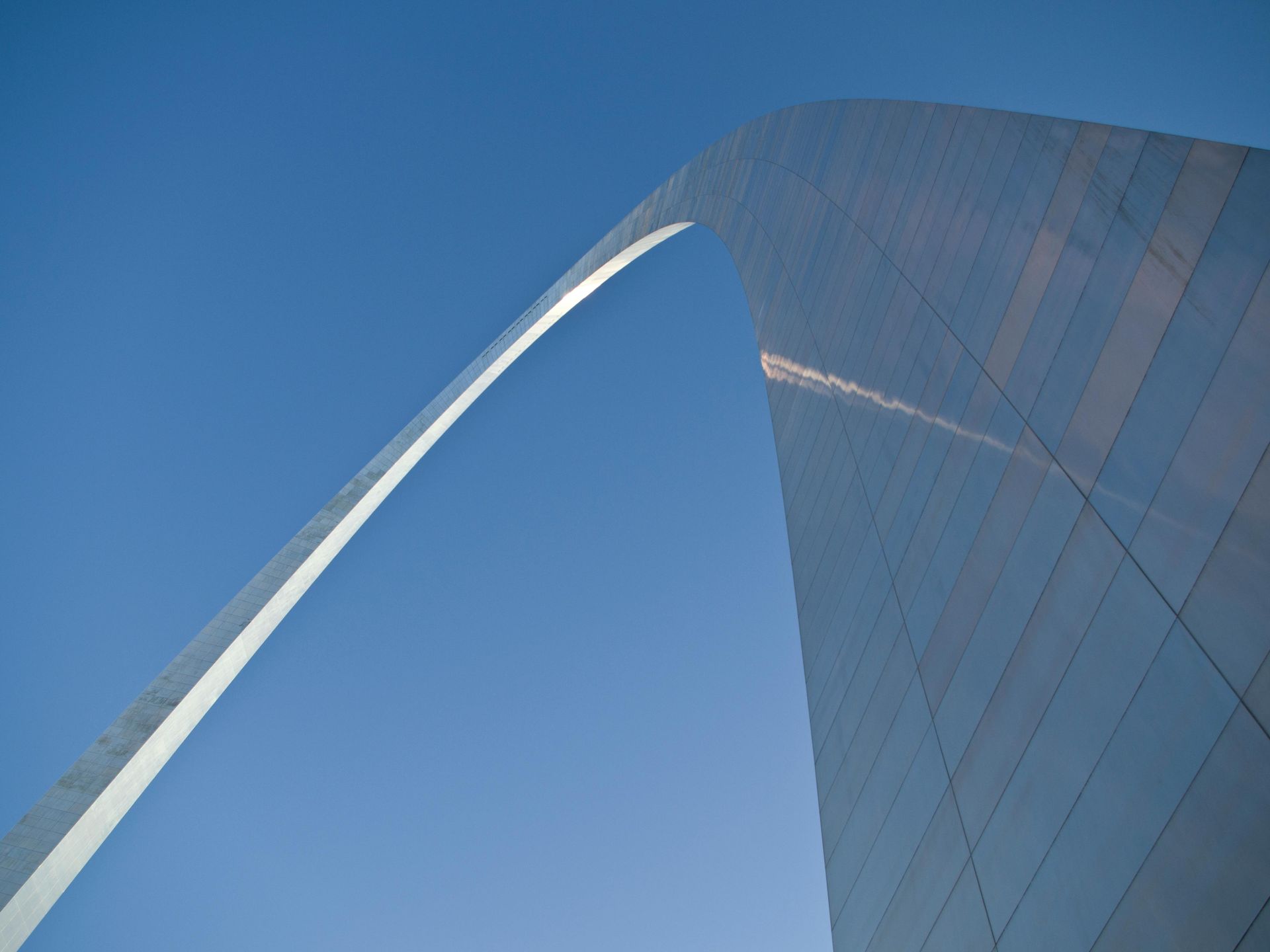 Looking up at the St. Louis Gateway Arch with a blue sky in the background