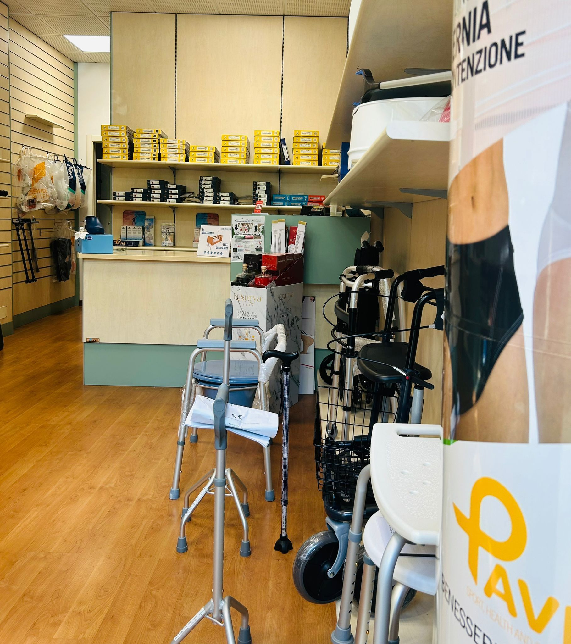 Interno di un negozio di forniture mediche. Deambulatori, sedie a rotelle e dispositivi di assistenza esposti sugli scaffali e sul pavimento.