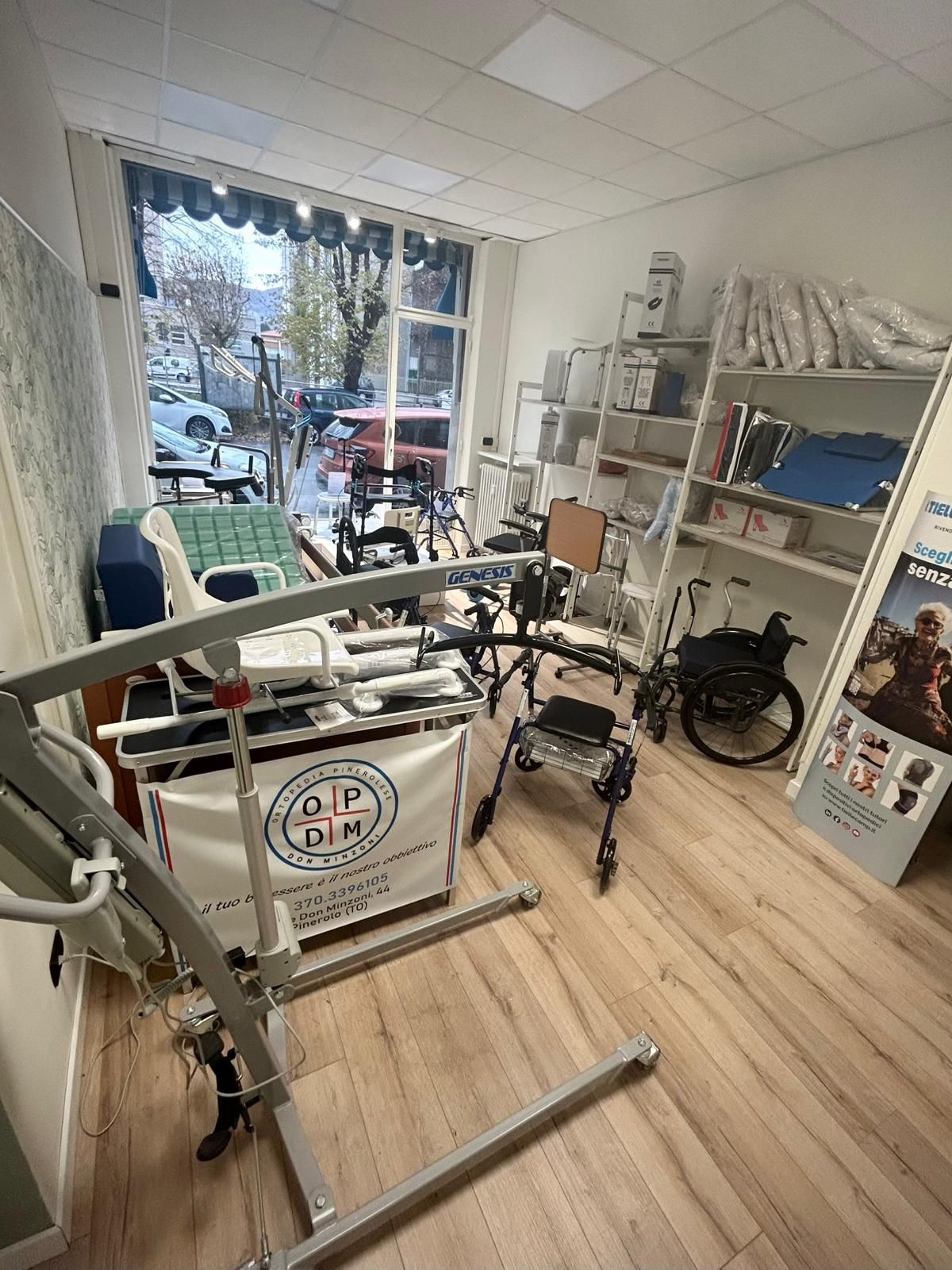 Vista interna di un negozio di attrezzature mediche. Vari ausili e prodotti per la mobilità sono esposti in una stanza luminosa.