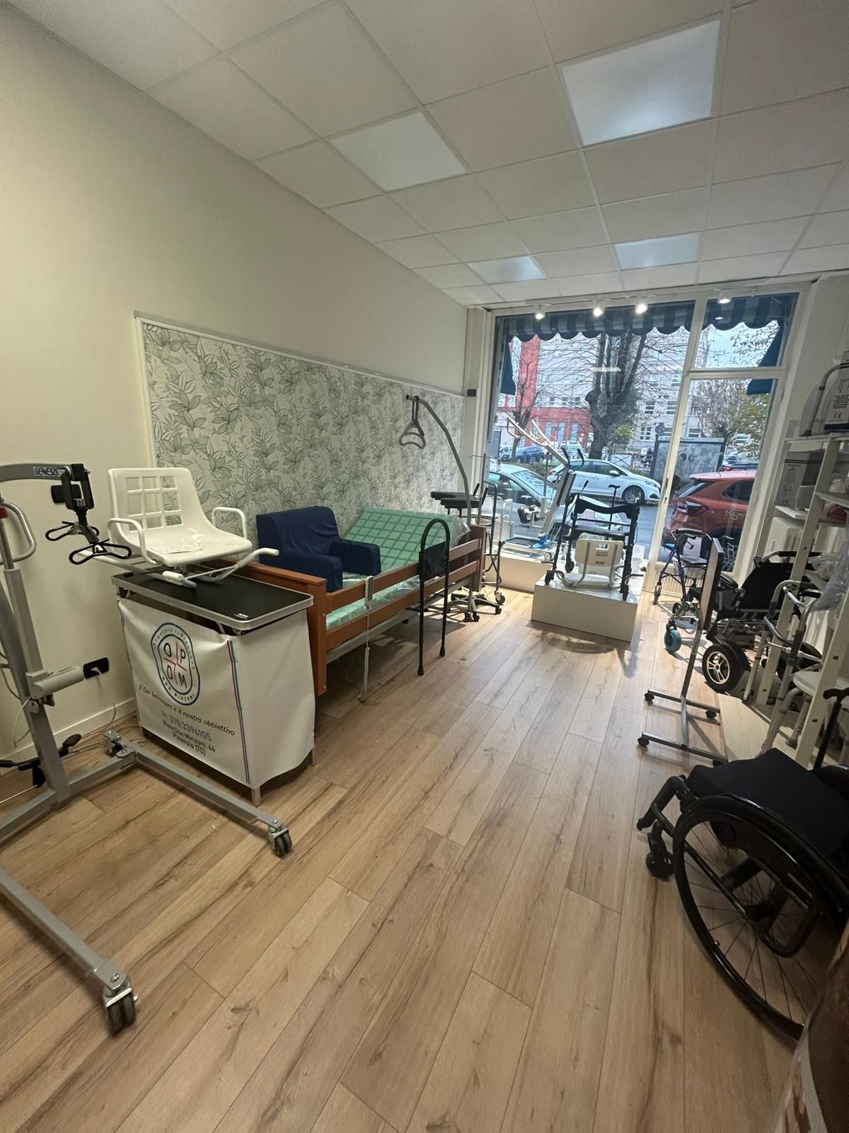 All'interno di un negozio di attrezzature per la mobilità, in cui sono esposti letti, ascensori, sedie a rotelle e altri dispositivi medici.