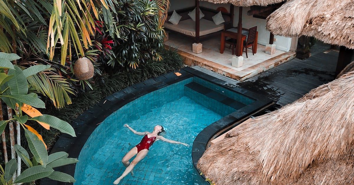 A woman is floating on her back in a swimming pool.