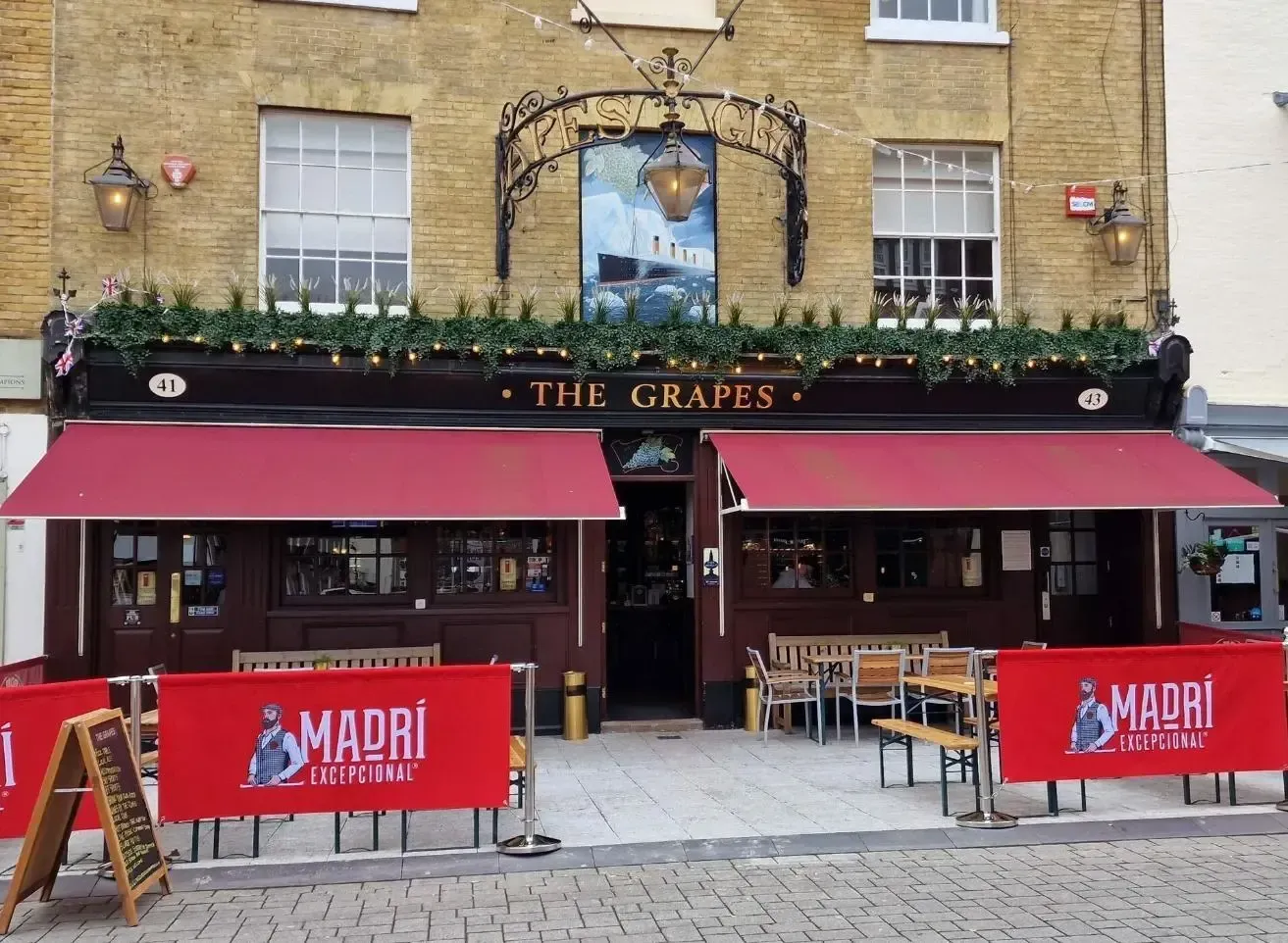 A restaurant called the grapes has a red awning