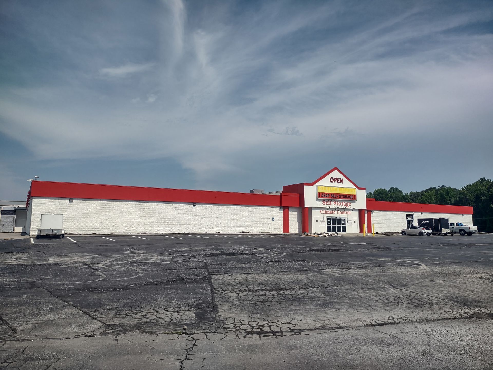 A large white building with a red roof and a yellow sign