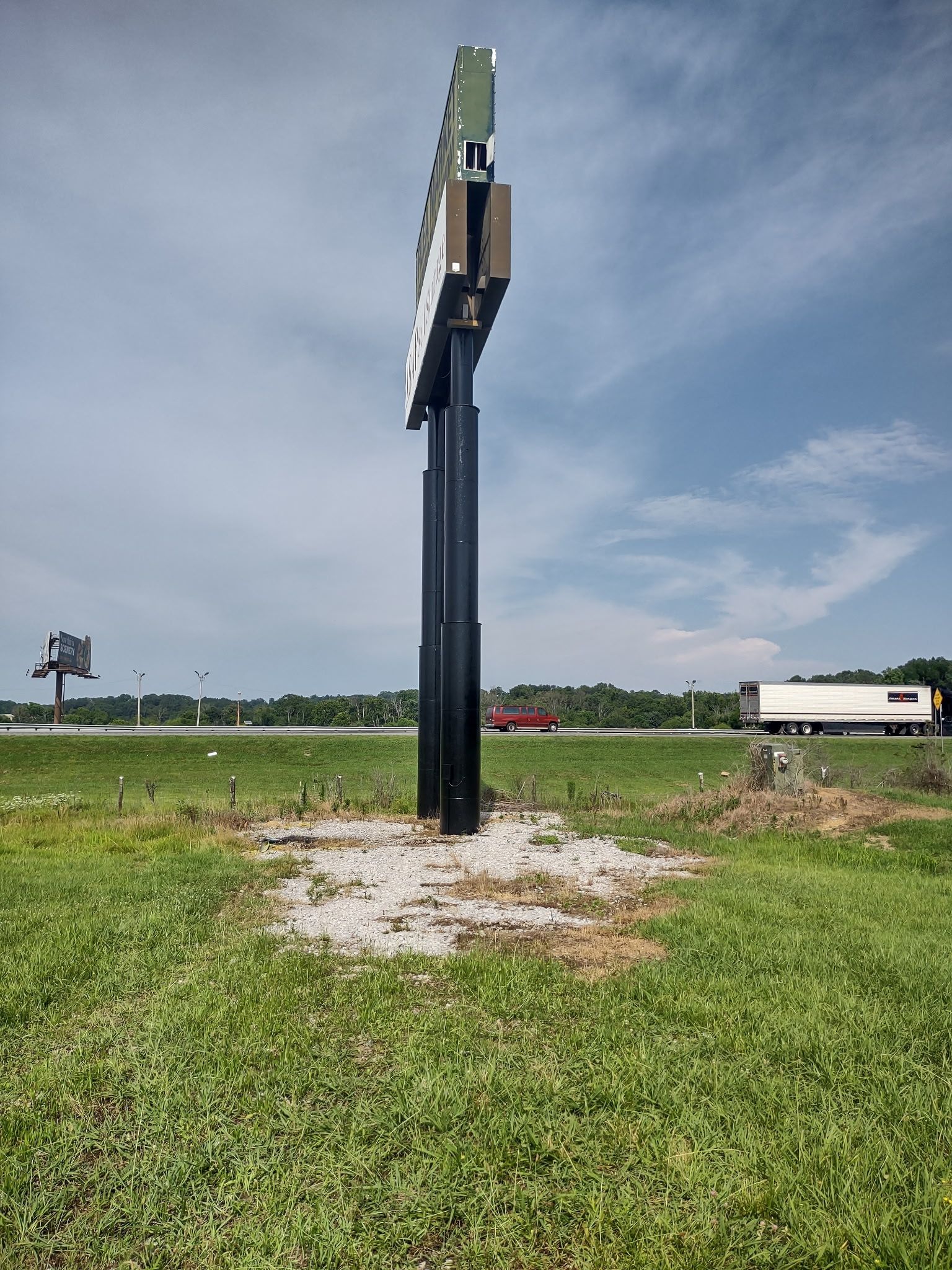 A large billboard in the middle of a grassy field