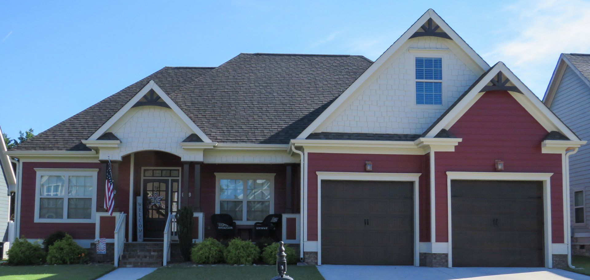 A red and white house with two garage doors
