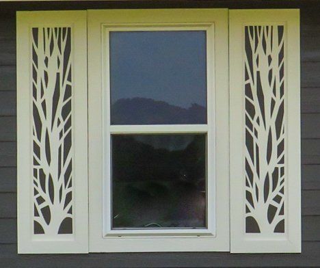 A window with a tree design on the side of it