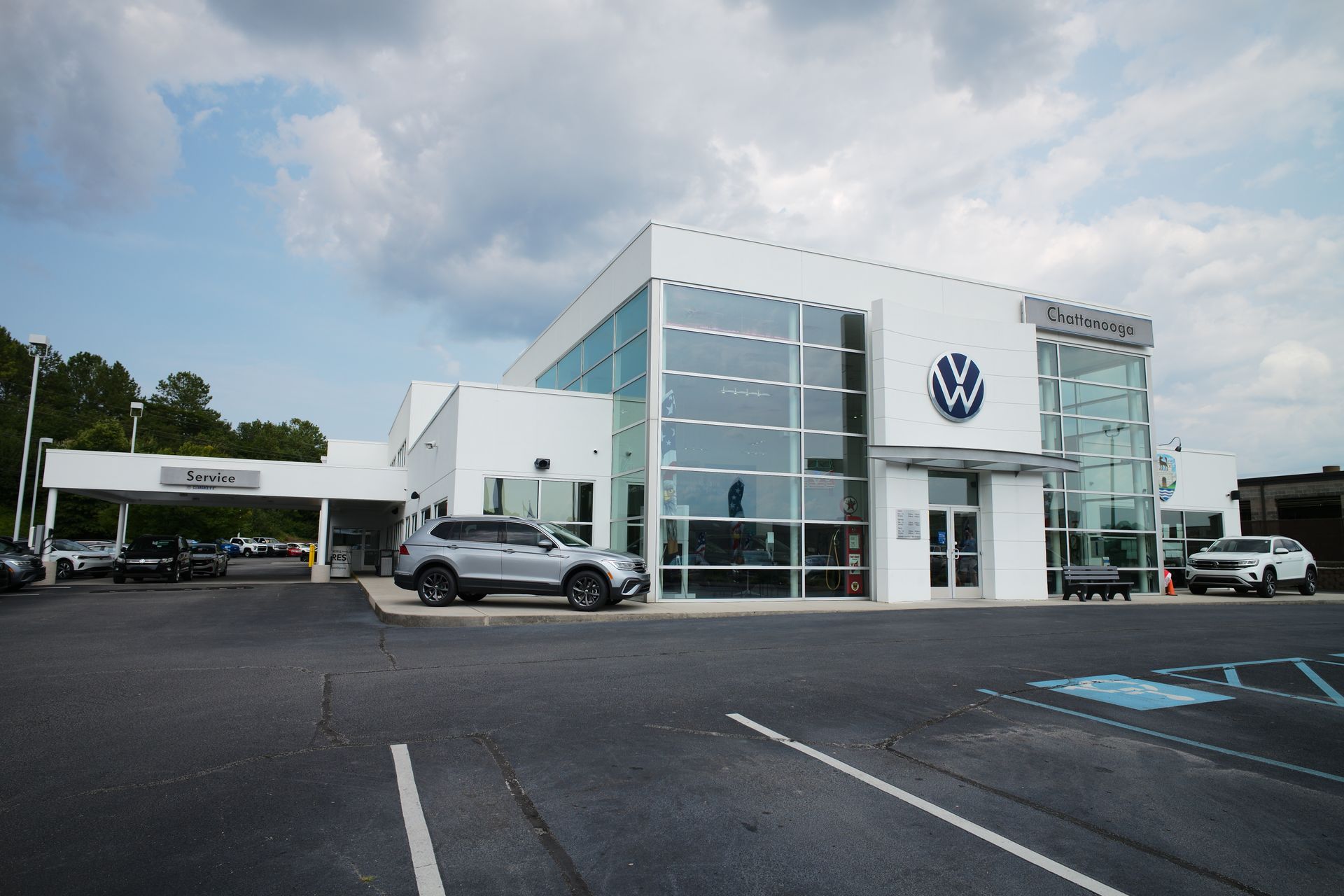 A car is parked in front of a volkswagen dealership.