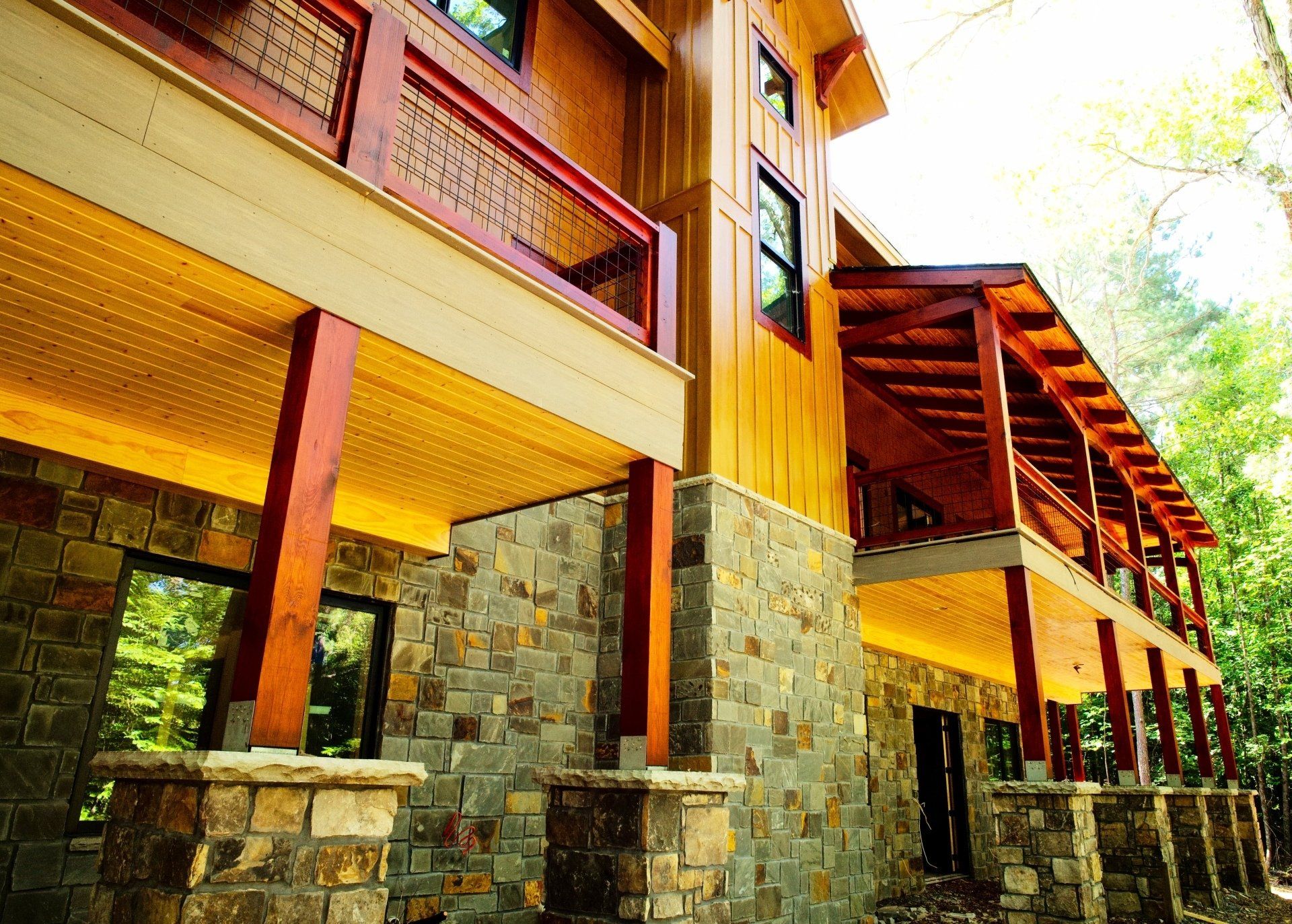 A large wooden and stone house with a large porch