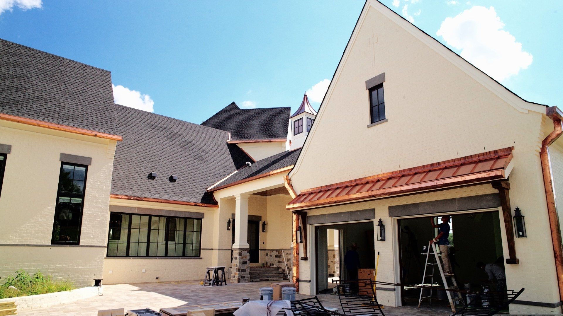 A large white house with a copper gutter is being built.