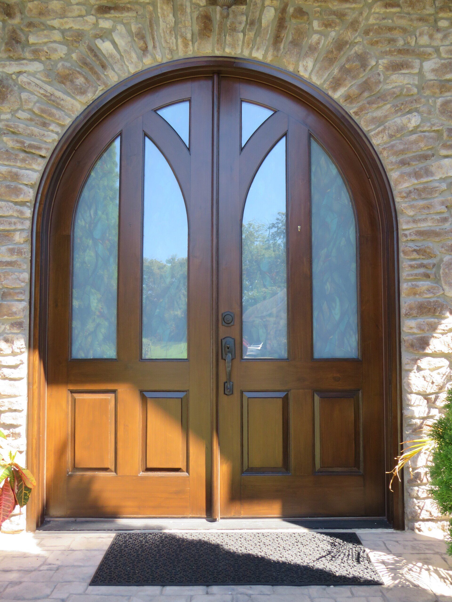 A wooden door with a brick wall behind it
