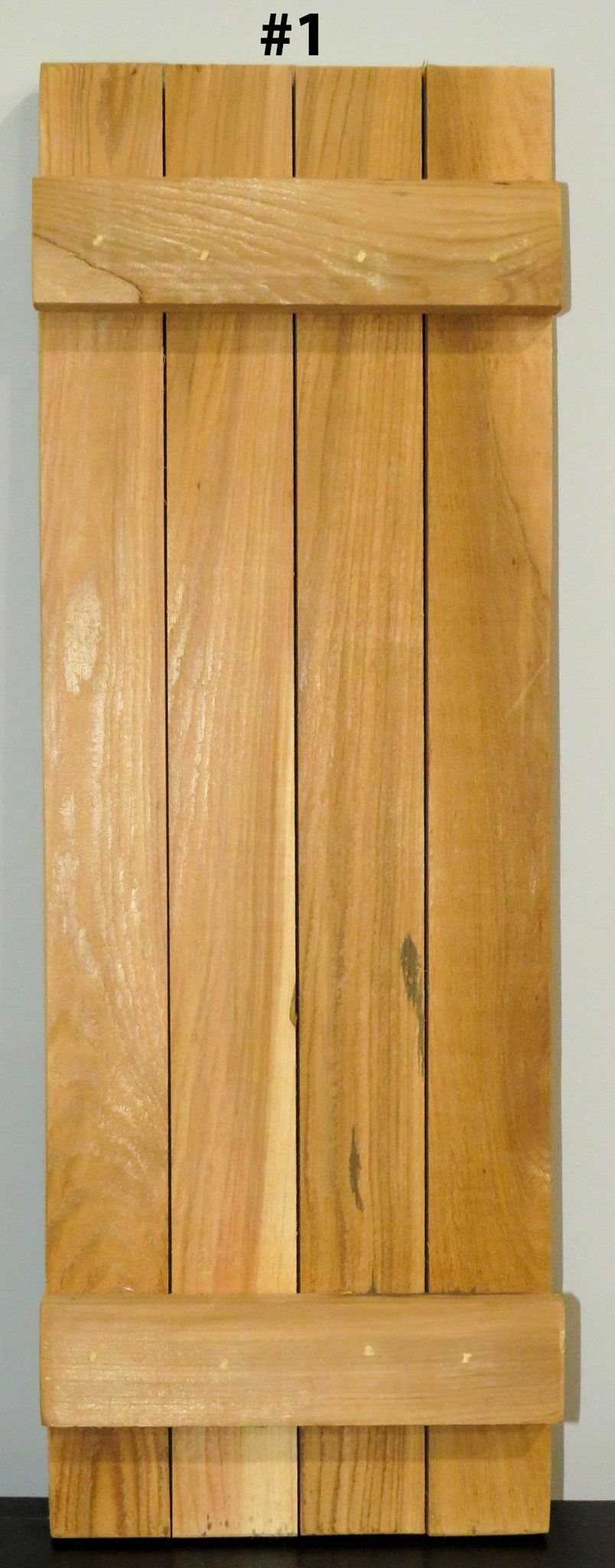 A wooden shutter with the number 1 on it is sitting on a table.
