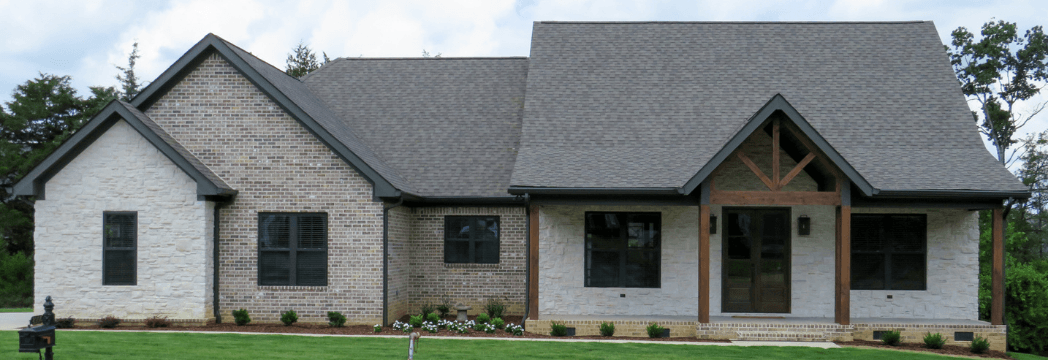 A large white house with a gray roof and black windows