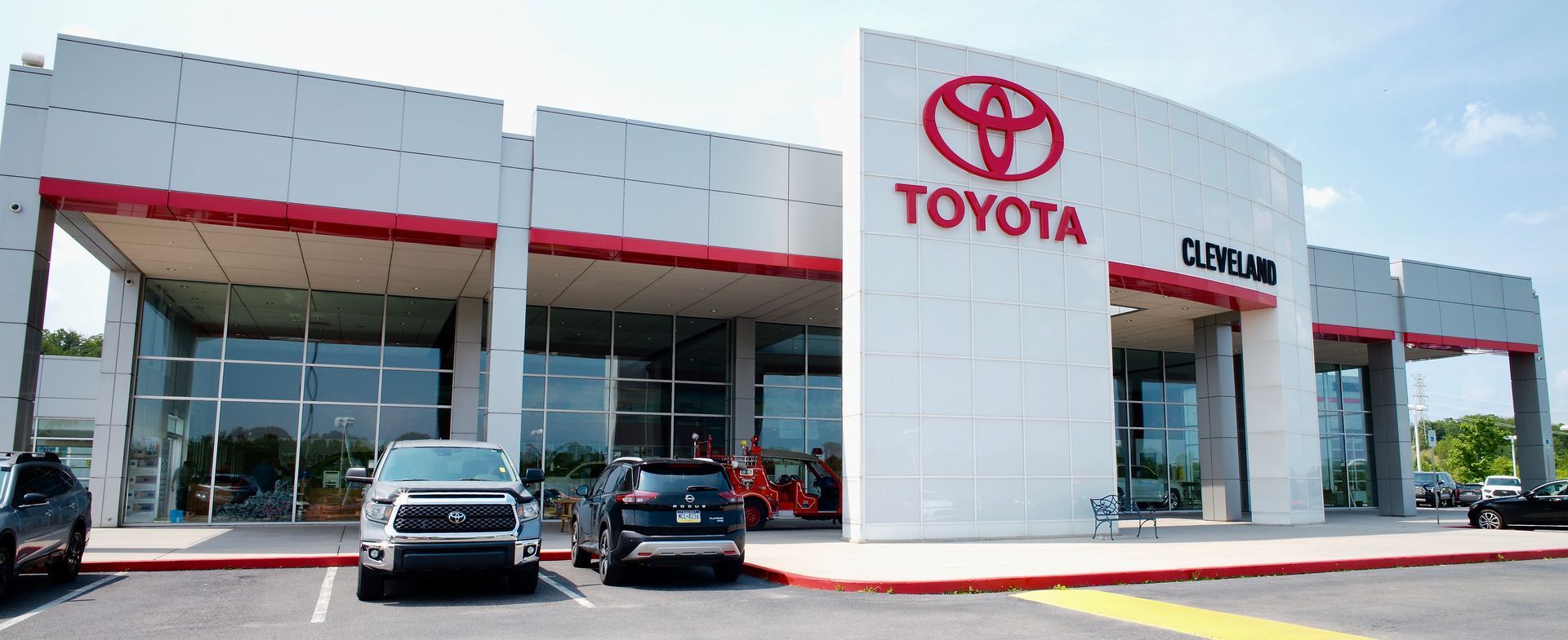 A toyota dealership with cars parked in front of it.