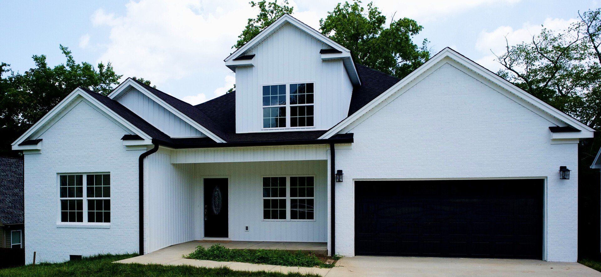 A large white house with a black garage door