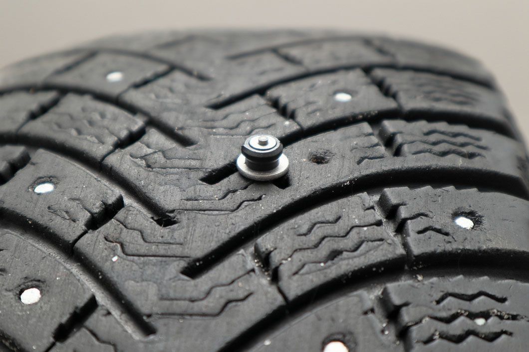 A close up of a tire with spikes on it.