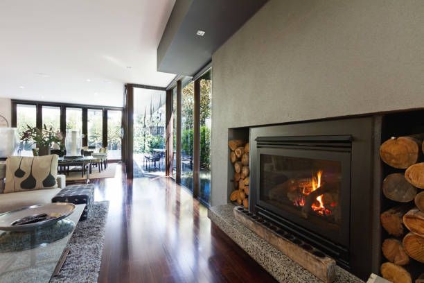 Living room with fireplace, wood floor, and open doors to a patio.