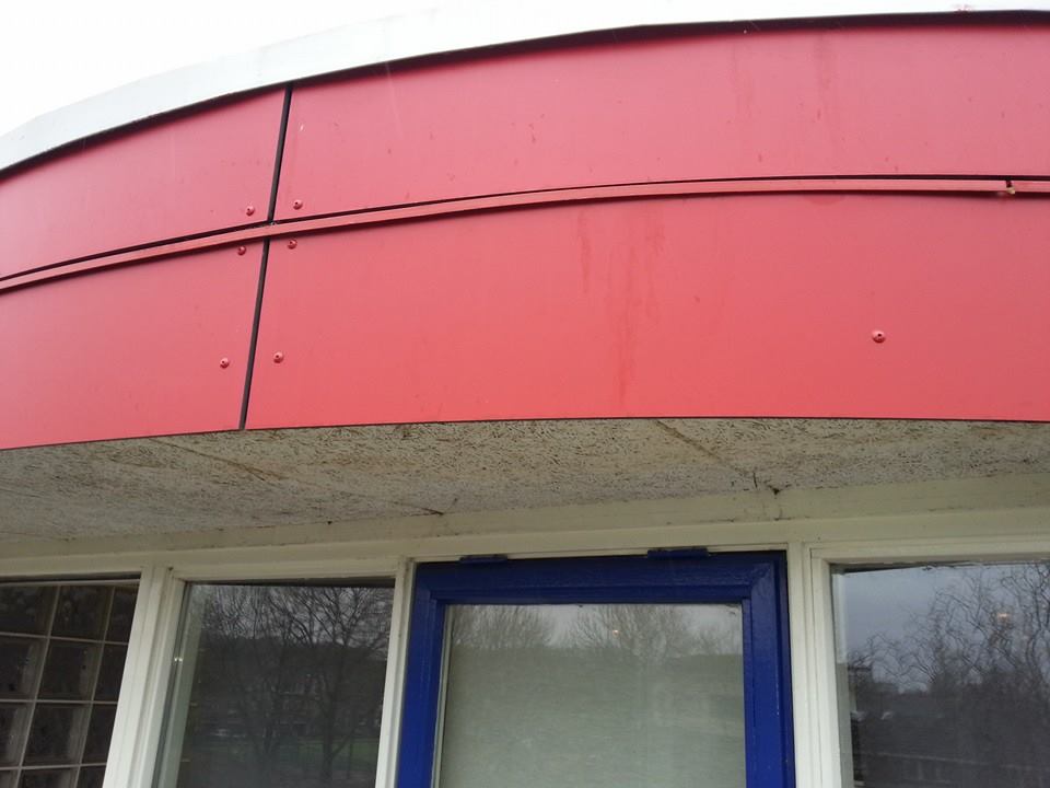 Een rood-wit gebouw met een blauwe deur