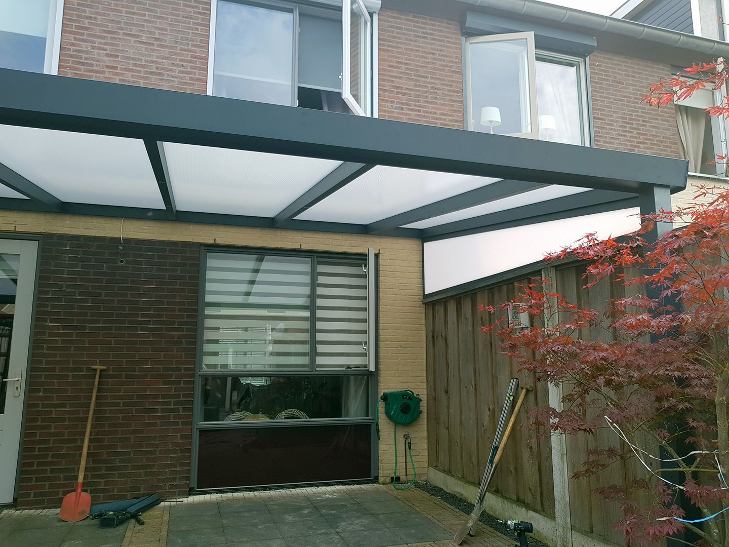 Een huis met een luifel erboven en een schep ervoor.