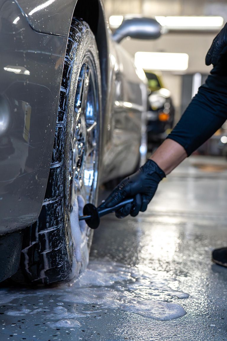 A group of men are working on a car in a garage.