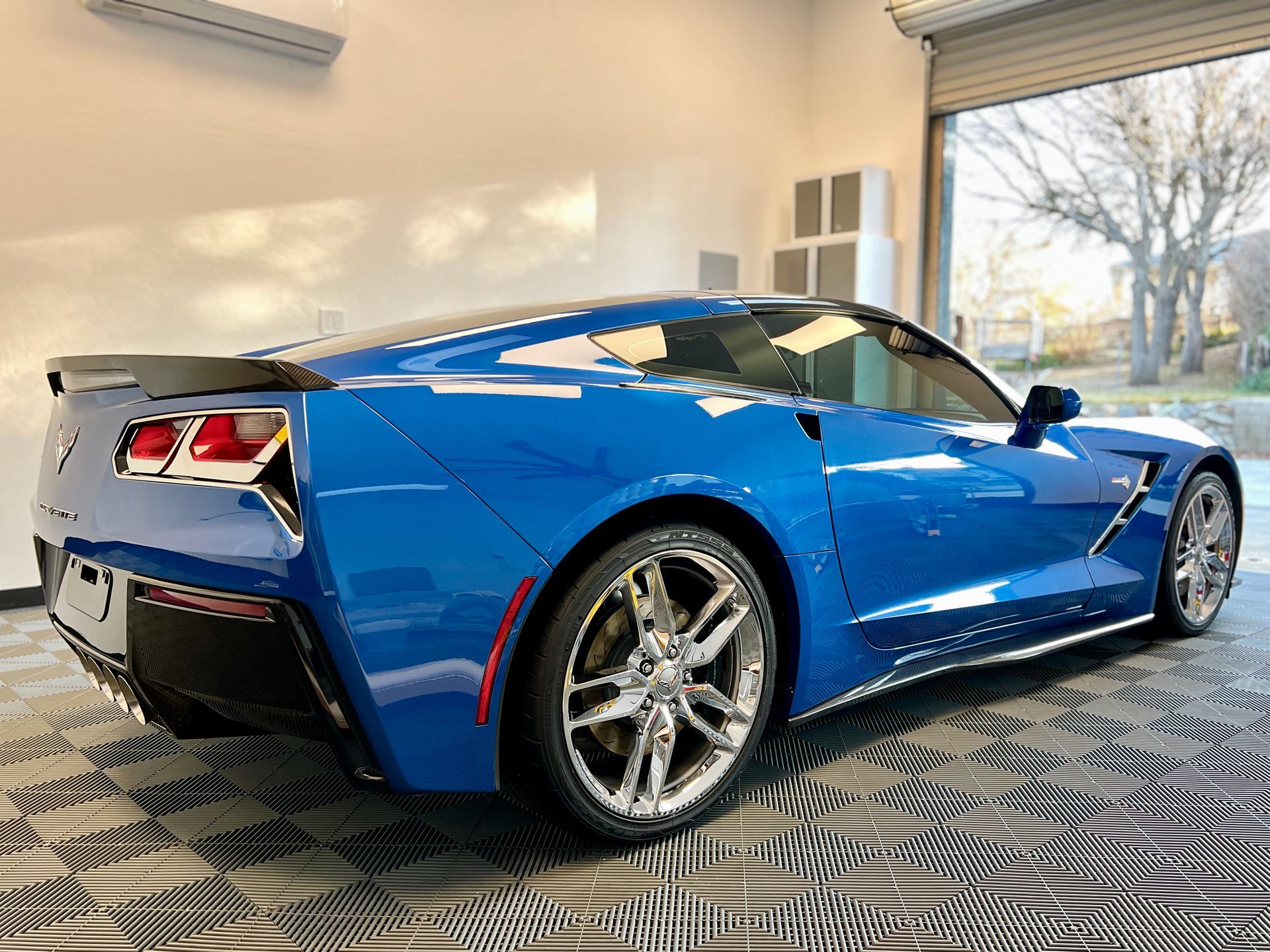 A blue sports car is parked in a garage.