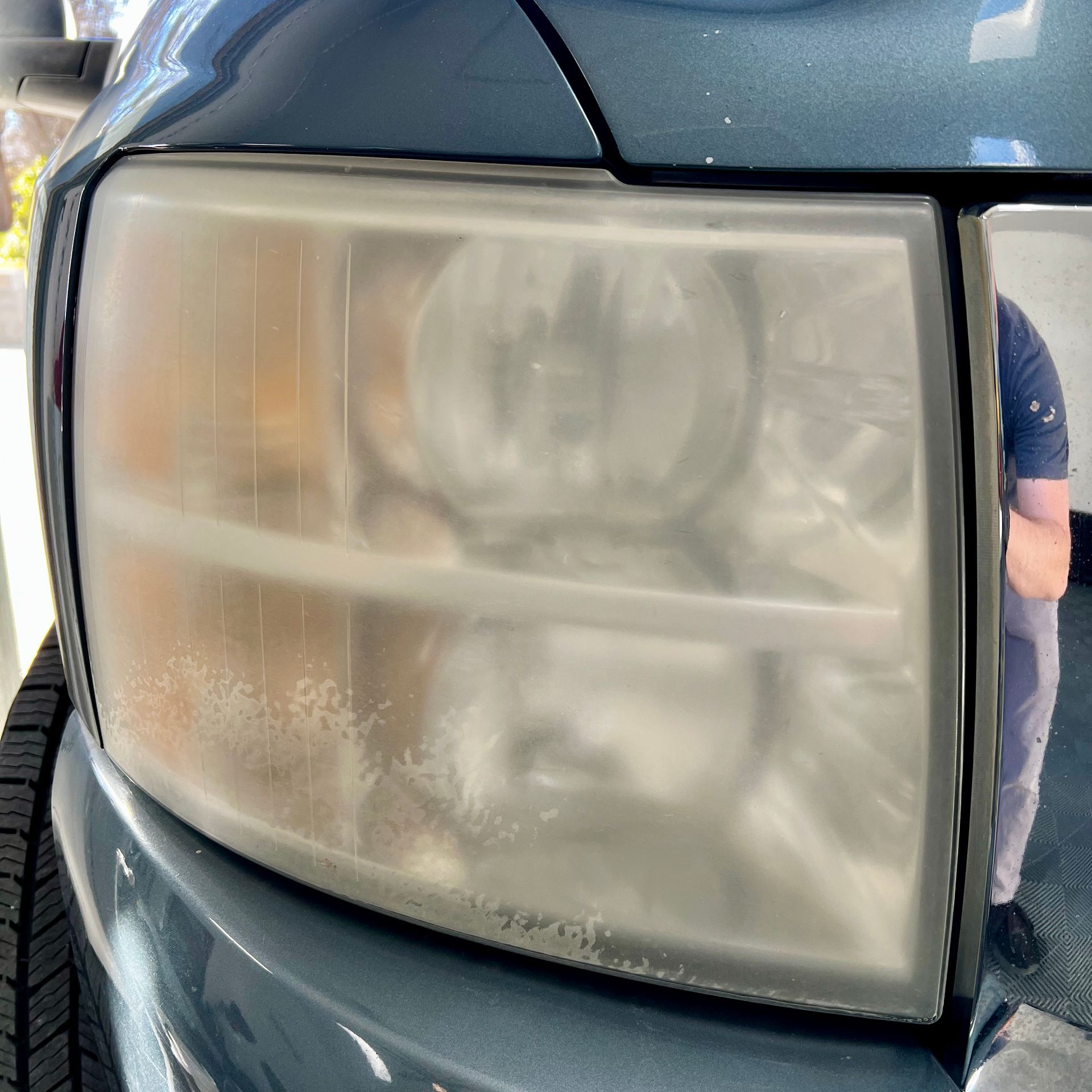 A close up of a dirty headlight on a car