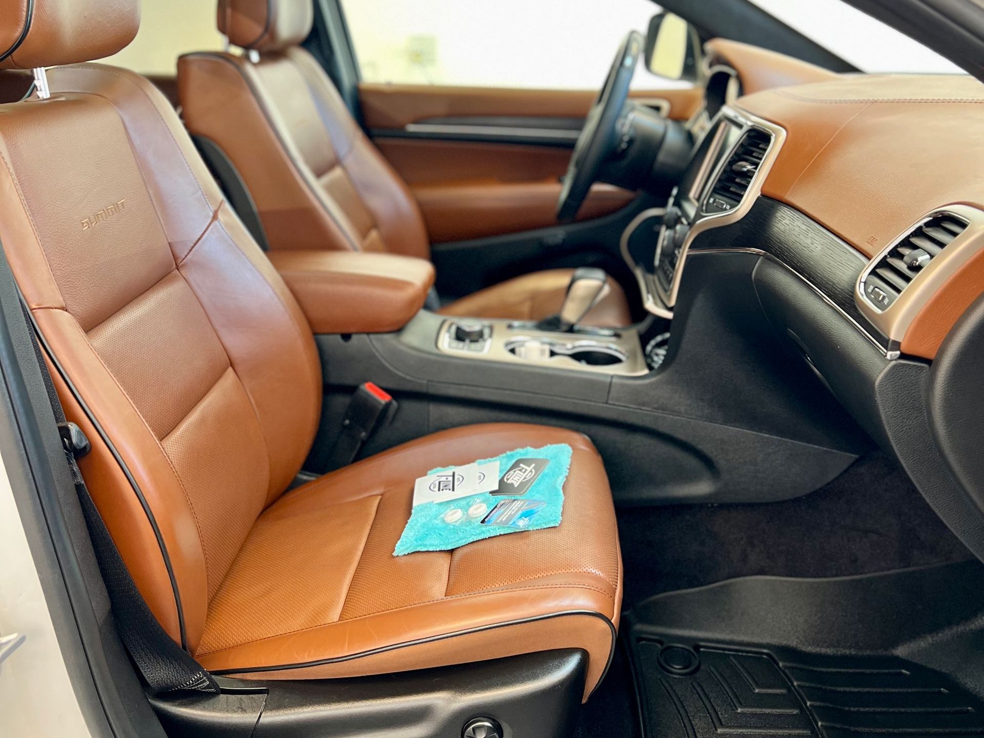 The interior of a jeep grand cherokee with brown leather seats