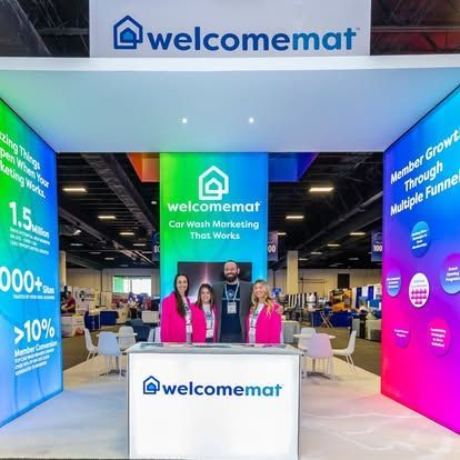 WelcomeMat booth with staff at a conference. Features