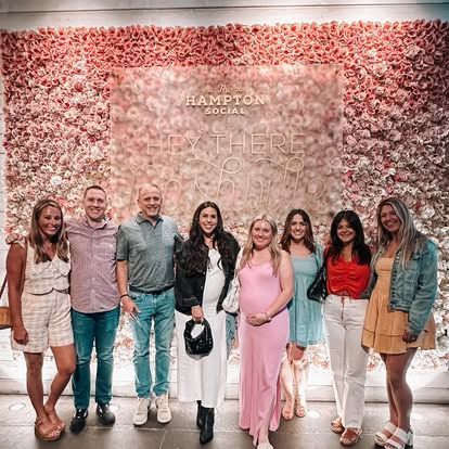 Group of people posing in front of a flower wall with