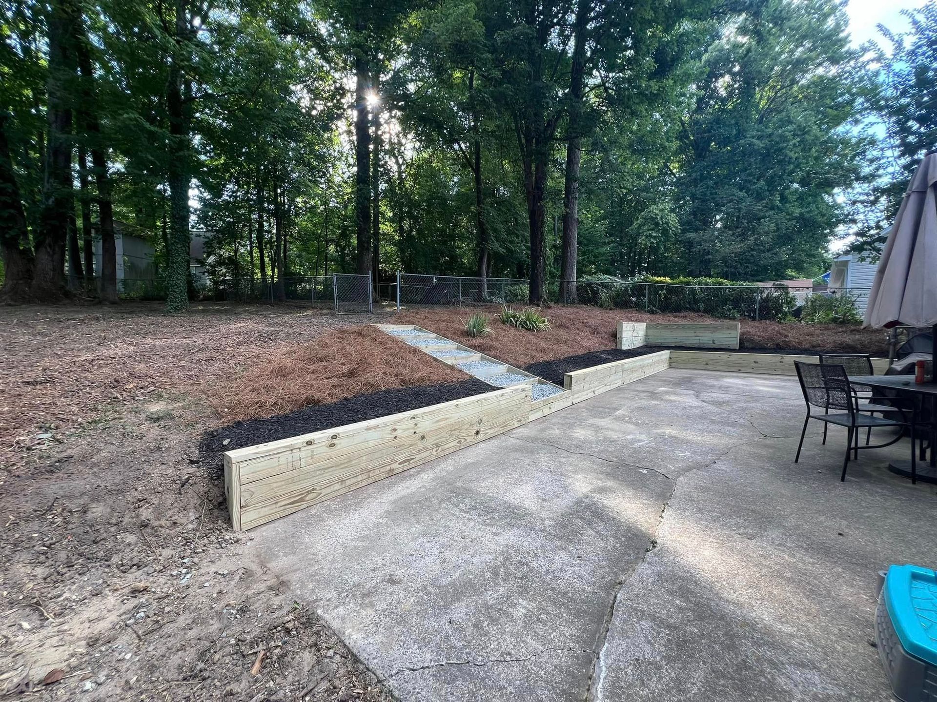 There is a patio with a table and chairs in the backyard.